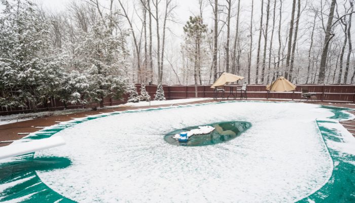 Piscine sous sa couverture d'hiver, dans la neige