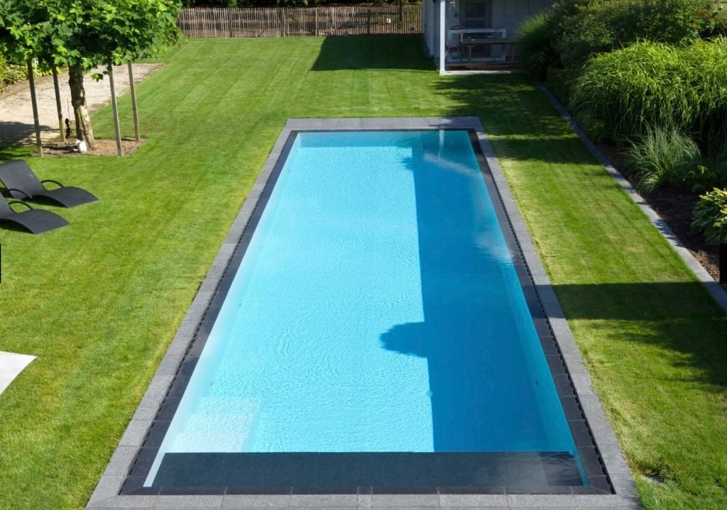 Piscine creusée entourée de pelouse, eau limpide